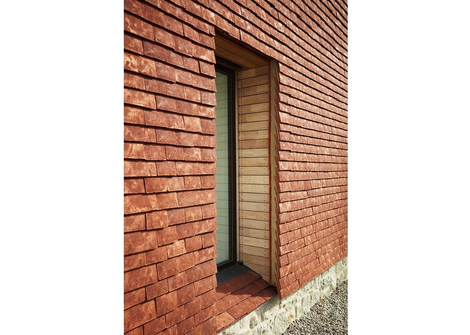 Detail showing loally-sourced sweet chestnut cladding alongside hand-made ceramic tiles.