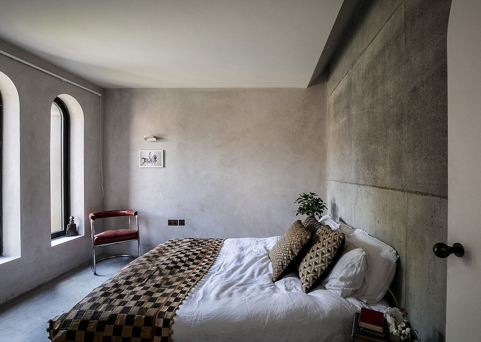 The main bedroom has a mix of raw concrete walls and clay plaster.