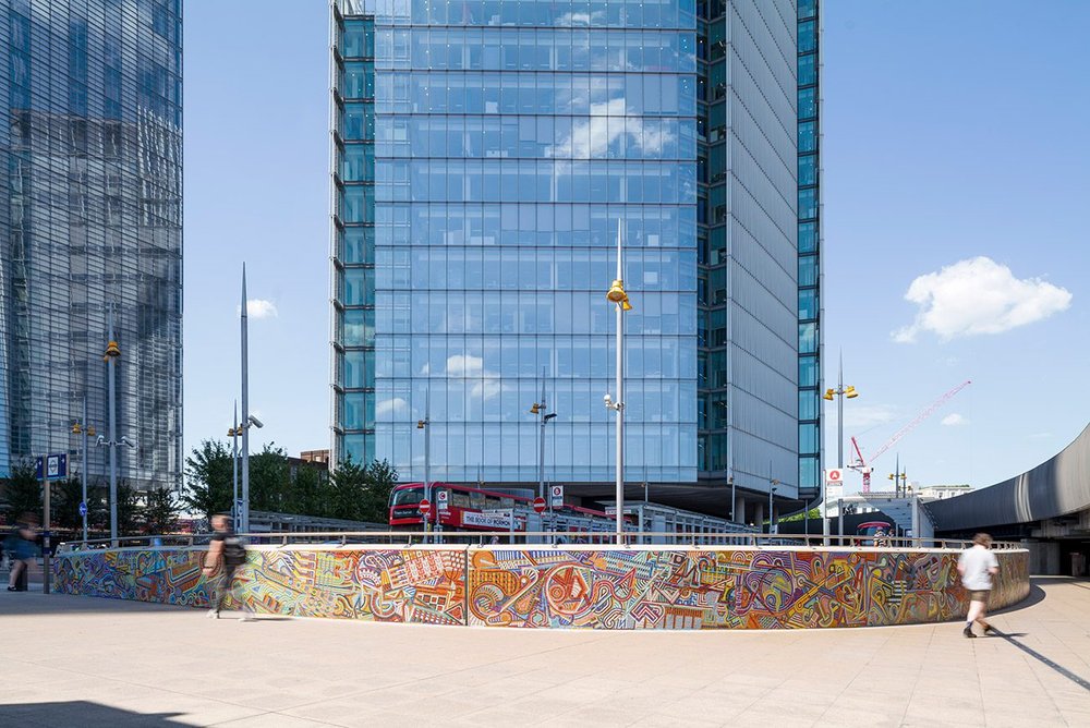 The hand-made mural is a pleasing counterpoint to the glassy architecture nearby.