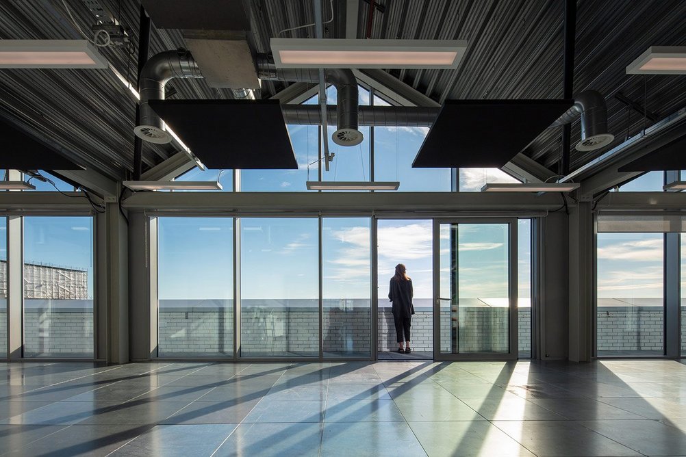 The top floor of the office building was conceived as a self-contained creative space, with terraces offering views across the city and to the sea.