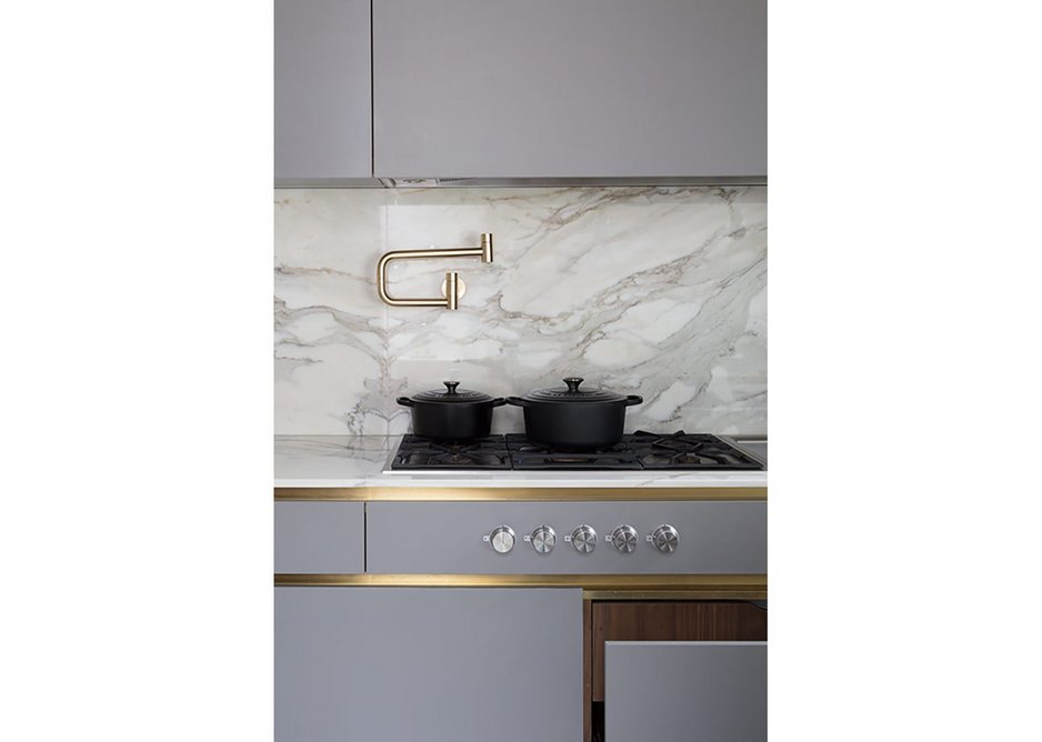 A matt lacquer bespoke kitchen and brass sheet cladding and detailing with Calacatta Oro marble work surfaces.