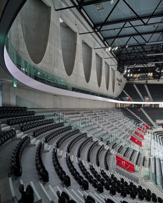 Although the arena is a huge, black box, the firm has created simple, sculptural statements on a grand scale, allowing daylight to filter into the space.