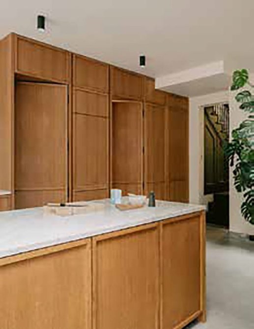 Oak cabinets in the marble-topped island unit tie in with the flanking oak joinery.