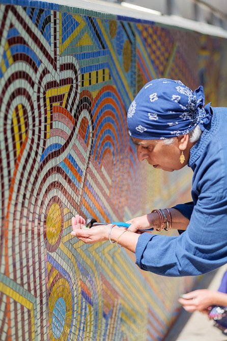 Volunteer Daljit Rai at work on In a River a Thousand Streams, a new mural outside London Bridge Station designed by Adam Nathaniel Furman.