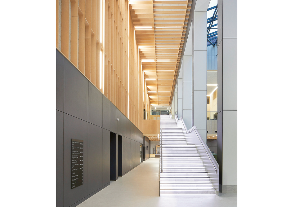 The grand connecting staircase runs up the atrium alongside the service spine.