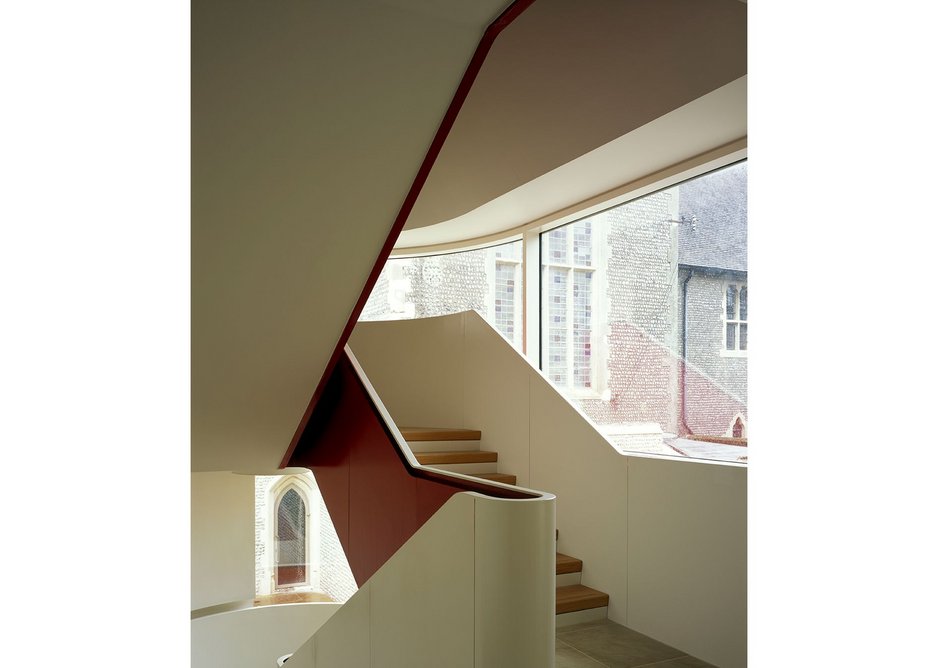 The winding steel stair overlooks the courtyard by the main entrance, its underside painted bright red.