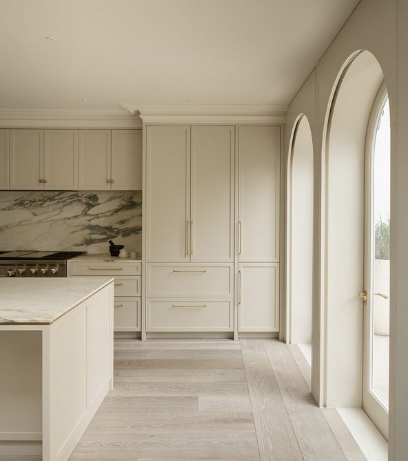 The Shaker kitchen’s neutral tones are offset with heavily veined Arabescarto Oro Verde marble tops and splashback. A shadow gap around the rear doors conceals tracked blinds.