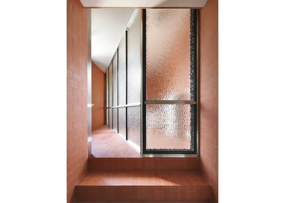 The simple brick ablution area has been split into four distinct spaces using framed mottled glass.