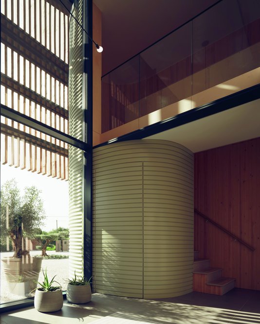 Green corrugated metal cladding on the elevation follows through around the stairwell in painted timber.