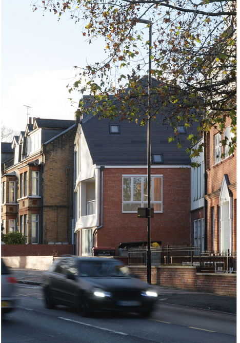 The building’s rear elevation faces West Hill, also known as the A3. Its steeply pitched roof leans away from adjacent Suffolk Hall.