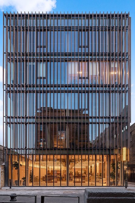 The timber louvres change in depth as they rise up the facade, protecting the building from solar gain.