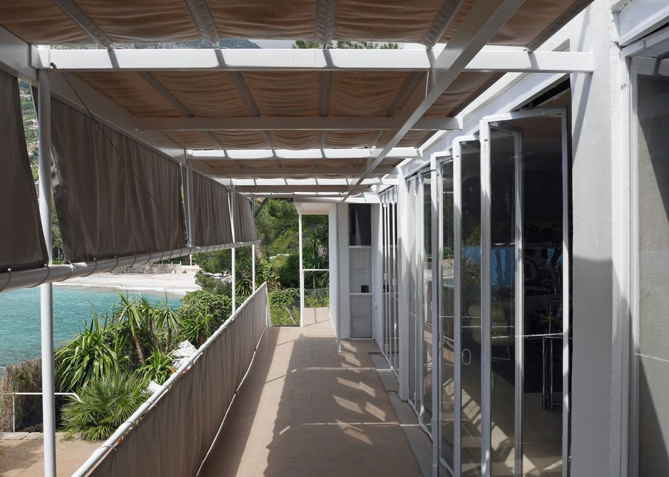 Folding glass wall opens onto shaded balcony.