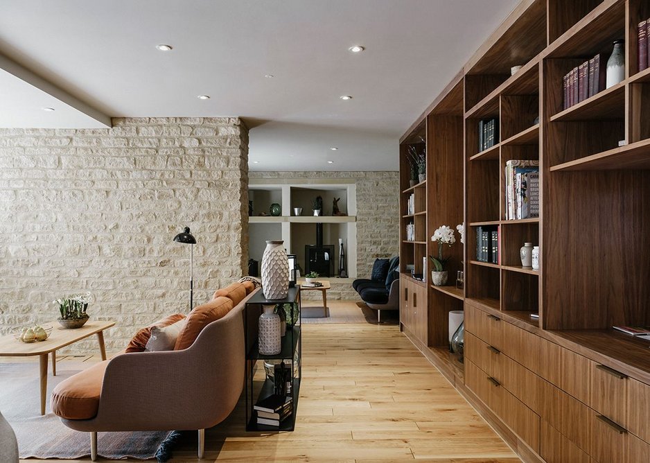 The residents lounge is gently divided into rooms by stone clad fin walls .