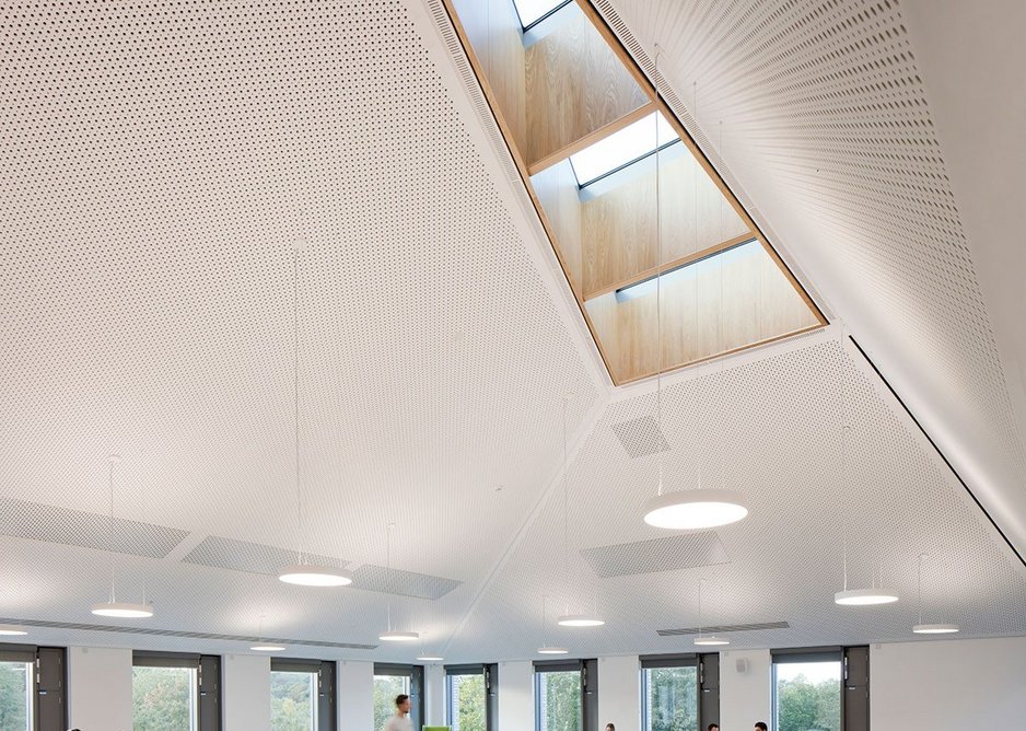 Built-in furniture mirrors the triangular rooflights above.