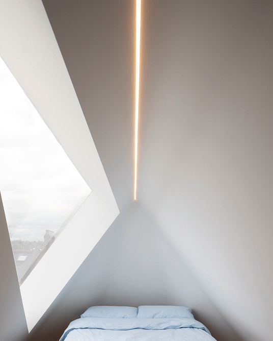 A triangular flat dormer ekes light out for an attic bedroom.