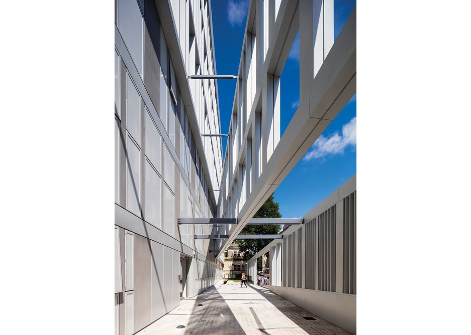 The freestanding screen is designed to mediate between the building and street, creating a small outdoor sitting area at the end.