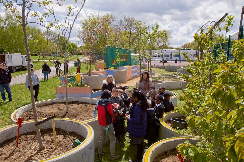 Members of the gardening club from the nearby school tend the planters.