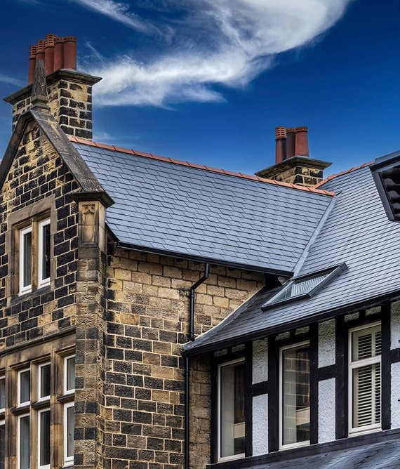 Red clay ridge tiles contrast with the natural slate.