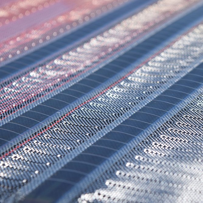 The water-resistant textile is created by weaving together OPV  solar cells with recycled polymer yarns
