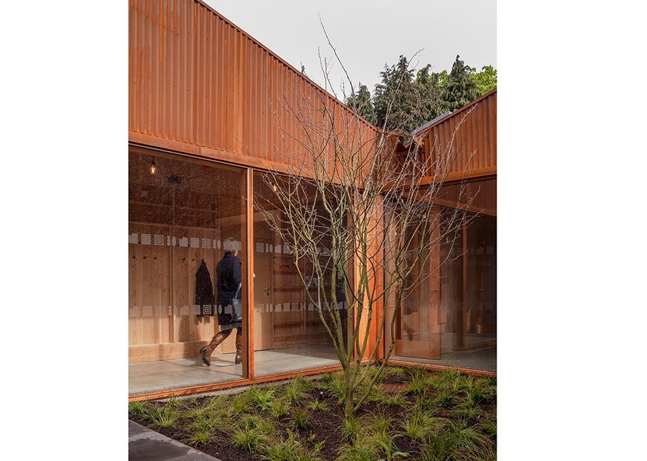 The green of the courtyard is enclosed by the unexpected gables generated by the series of roof pitches.