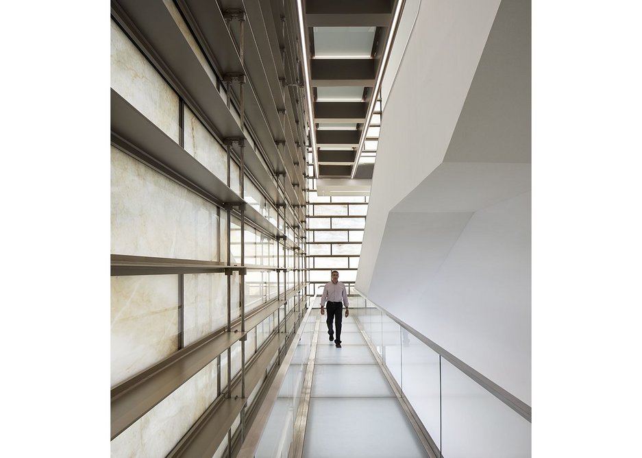 Daylight passing through the marble wall creates decorative shadows during the day in the cube’s stairwell.
