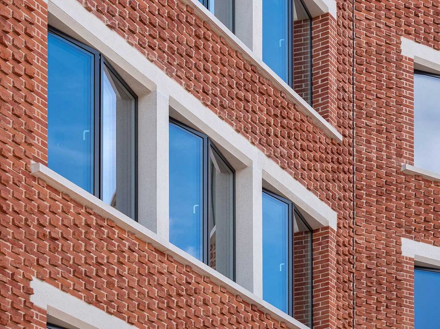 The crisp white of the cast stone window surrounds contrasts strikingly with the red brickwork.