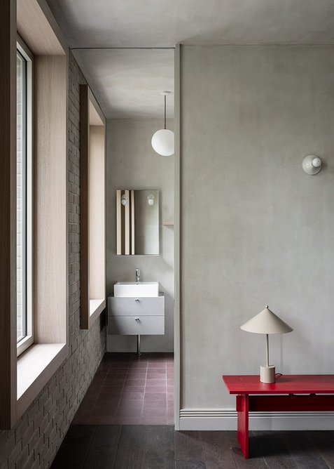 Clay plaster and timber accents soften the material palette.