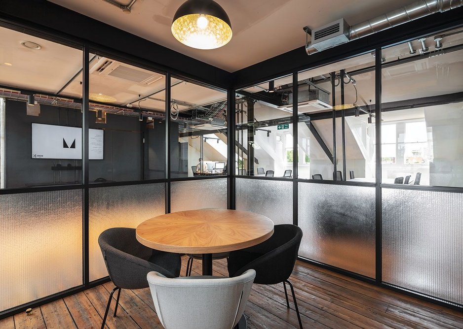 Japanese-style partitions, in glass, form offices and meeting rooms.