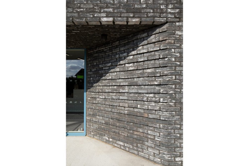 Brick detailing at the entrance evokes the stratification of the chalk caves below.