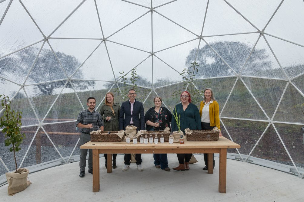 PLACE Architects’ team in a geodesic biome at English Spirit, a gin distillery in Launceston, designed by the practice. The  distillery,  located in a converted barn, opened in September 2021. The domes are used to grow herbs for the gins.
