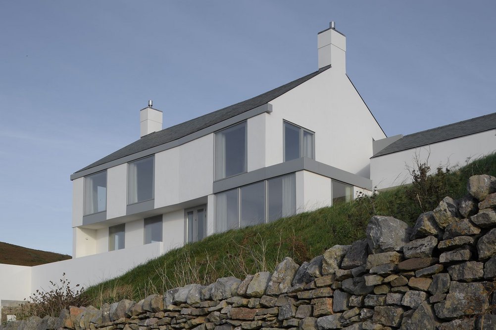 The façade elements set flush within the lime render combine to make a taught, robust exterior skin. The top part of the building steps out by 50mm to create a subtle play of light across the façade.