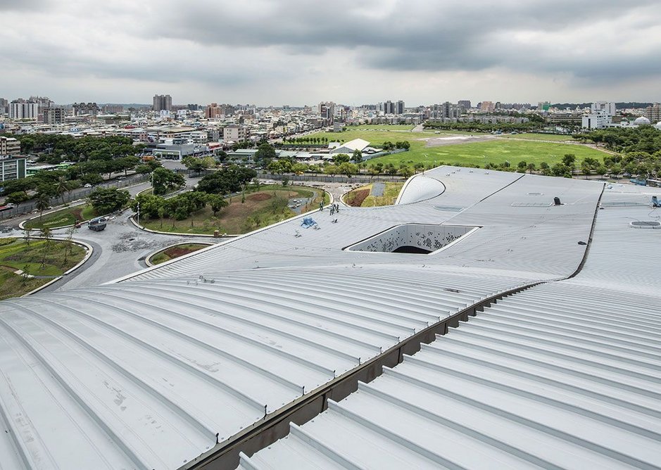 The standing seam roof channels water to the huge gutters, compartmentalising its massive area.