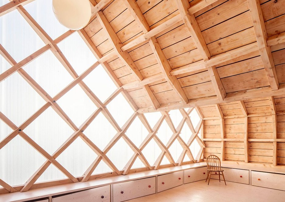 The expressed timber reciprocal frame of St. John's School Music Pavilion designed by Clementine Blakemore Architects at Lacey Green, Buckinghamshire. As part of the second phase of the project, the gable ends were clad in polycarbonate panels, with new storage created below.