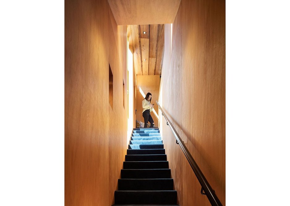 Ply-lined stair walls show off the rich blue nylon carpet – repurposed from a hospital.