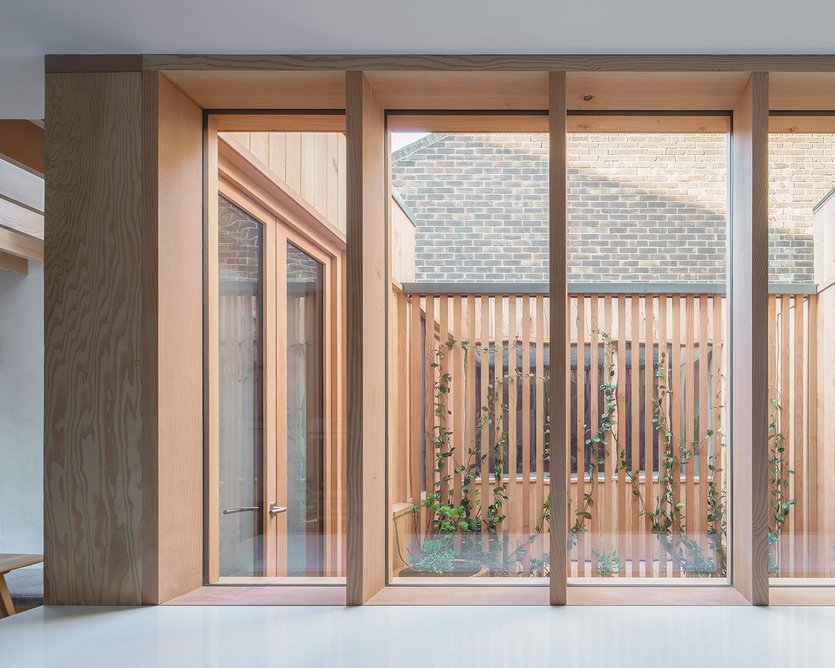 In the courtyard a concealed mirror between cladding slats seems to extend the space.