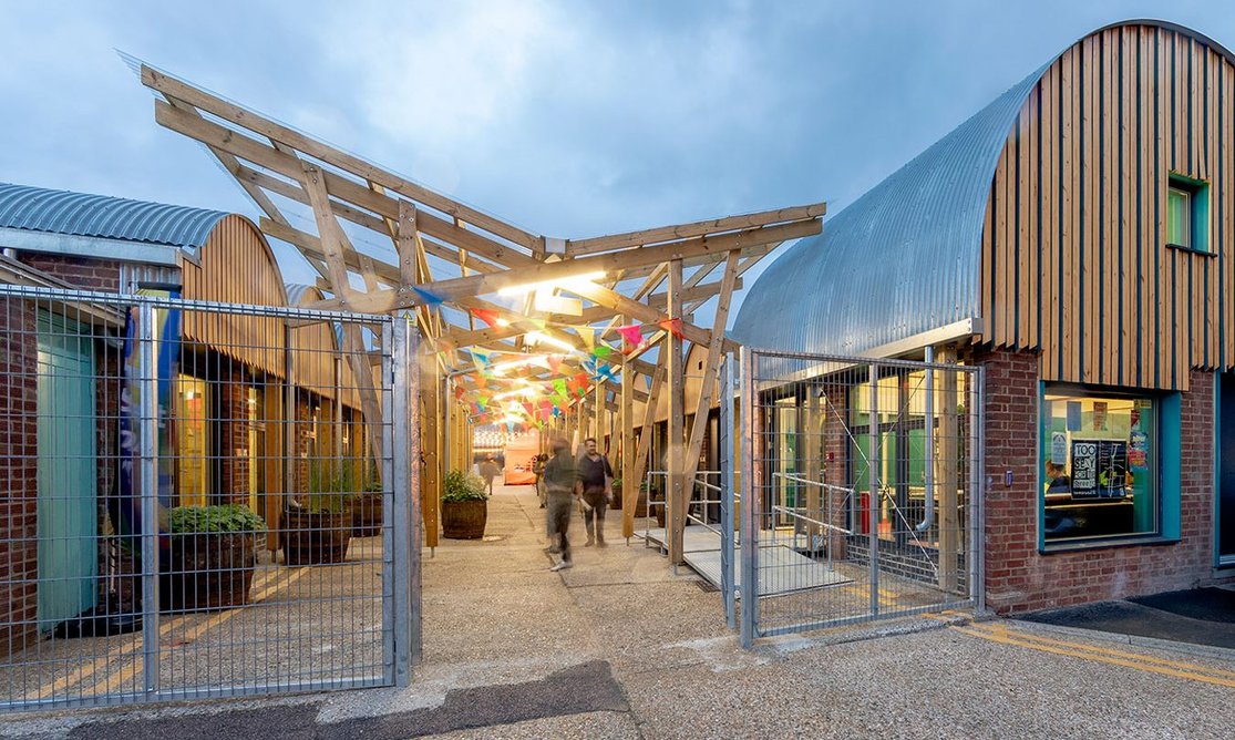 The street between garage-sized units, with its butterfly roof, now connects to Grove St, a traffic-free road beside a local primary, stitching into what’s already there.