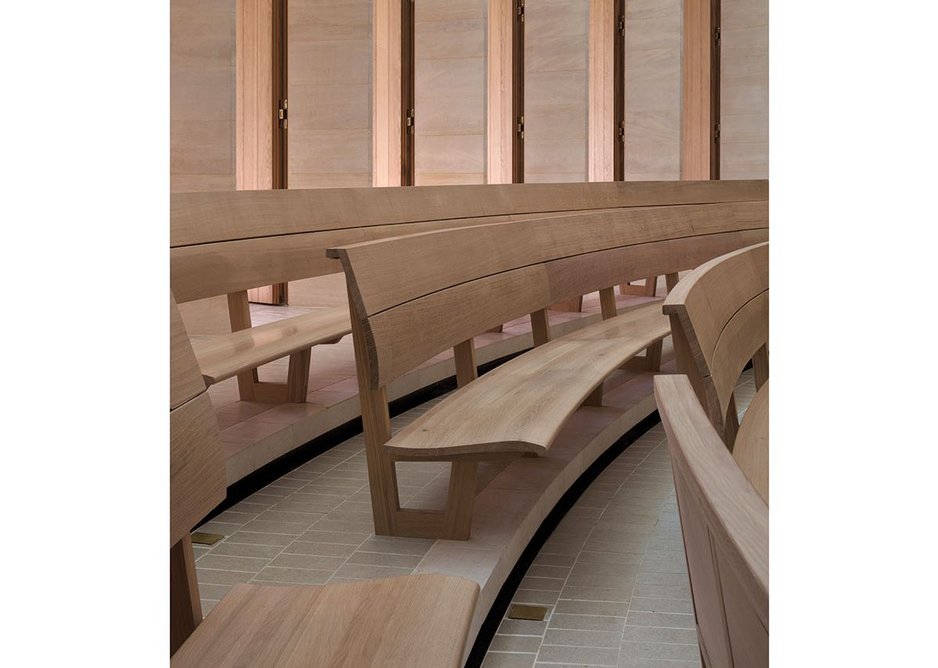 Oak benches are subtly curved for comfort. Writing flaps fold down from the back of each bench with the elegance of tiny bureaux.