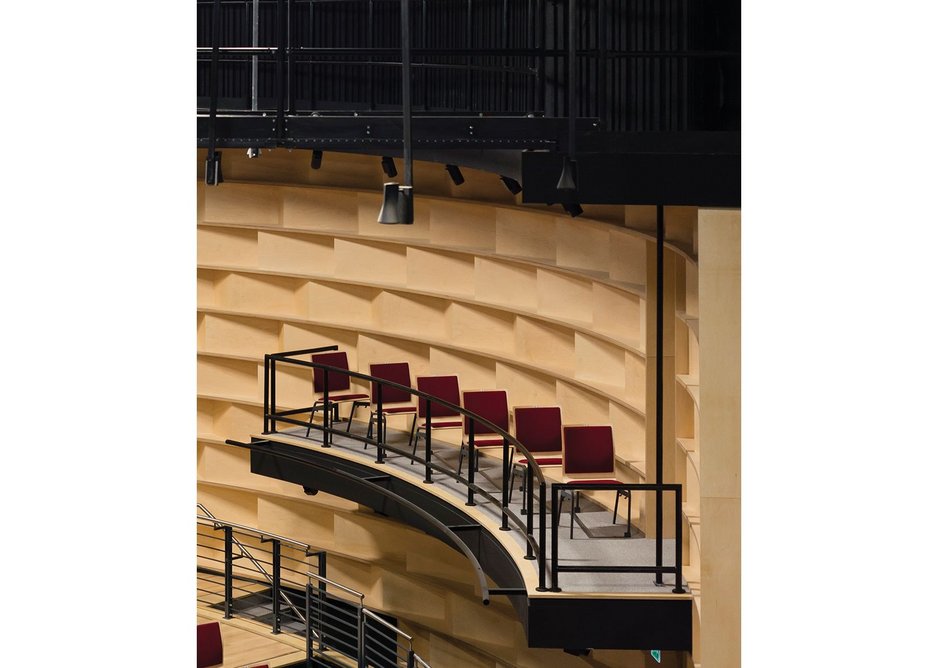 Auditorium walls are fitted with timber acoustic boxes.