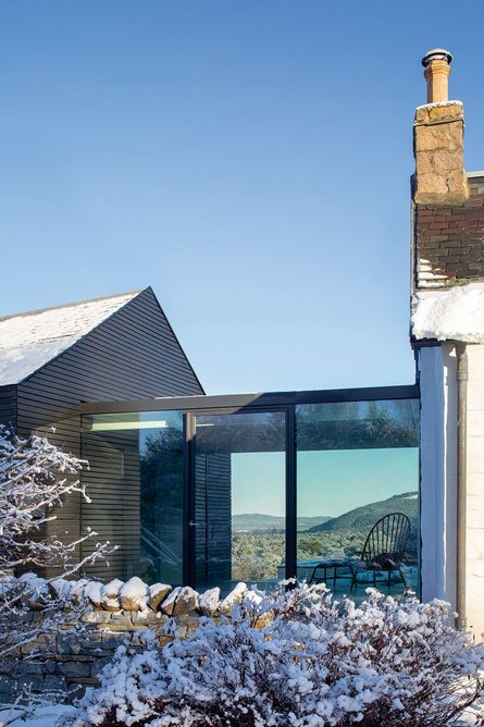 A glazed link joins the original house and new extension, also acting as a passive solar collector for the main house in the winter.