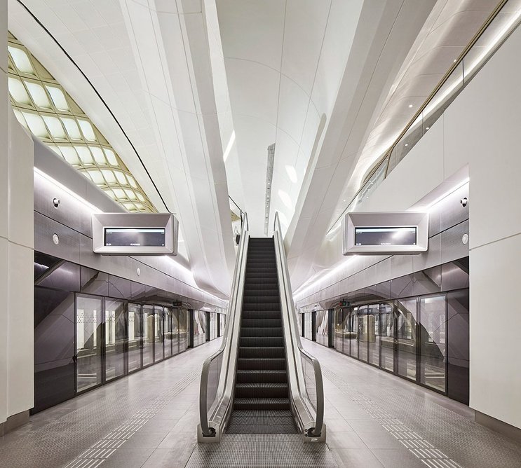 Escalators echo the canted uprights of the concrete frame.