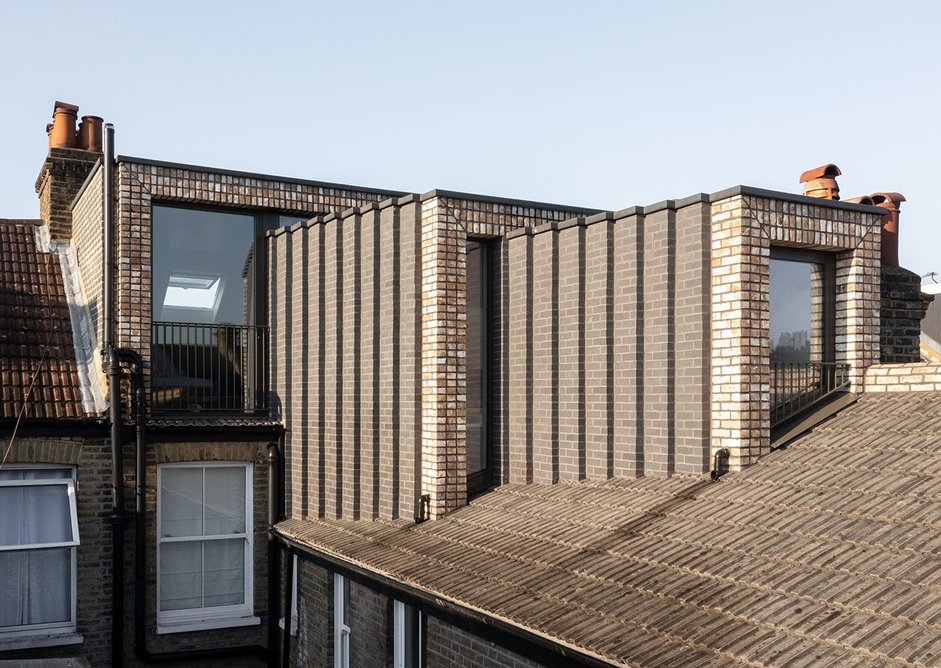 The stepping brickwork on the dormer’s cheeks accentuates the stepping logic of the massing.