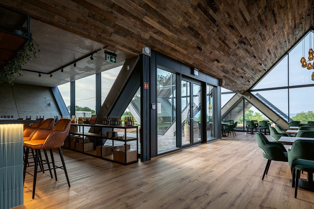 The ground floor hospitality zone is sandwiched between soffits of old reclaimed timber slats and a new engineered timber floor.