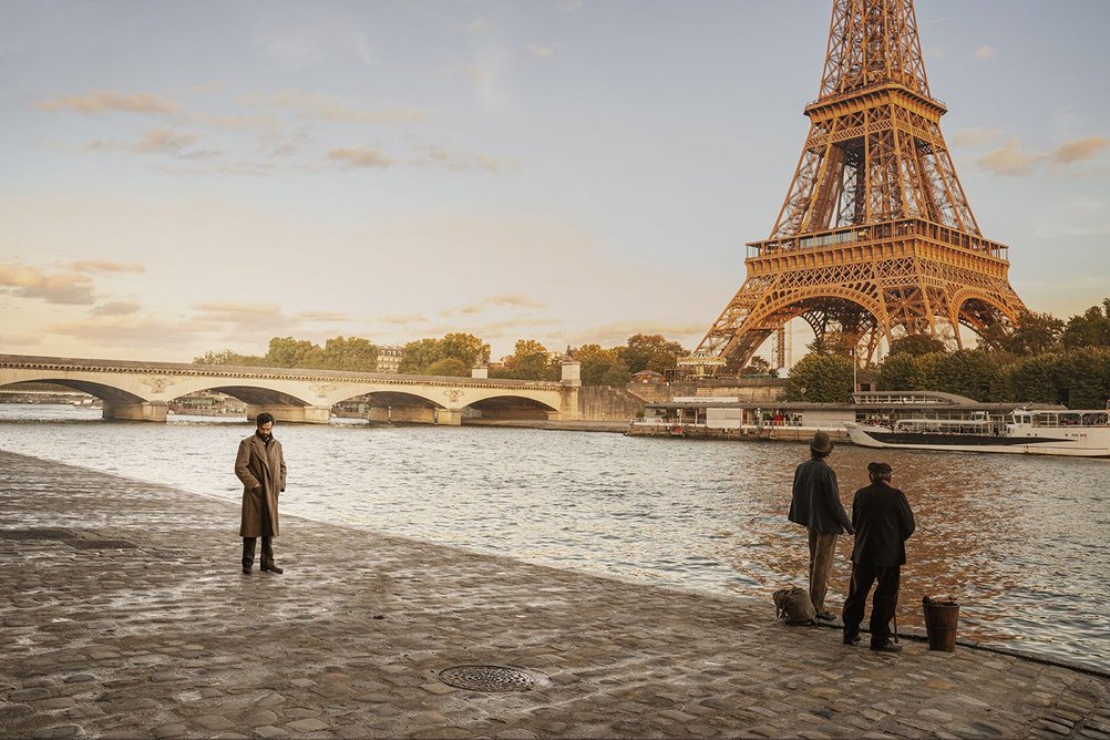 Gustave Eiffel (Romain Duris, left) with the completed tower in the film Eiffel, directed by Martin Bourboulon.