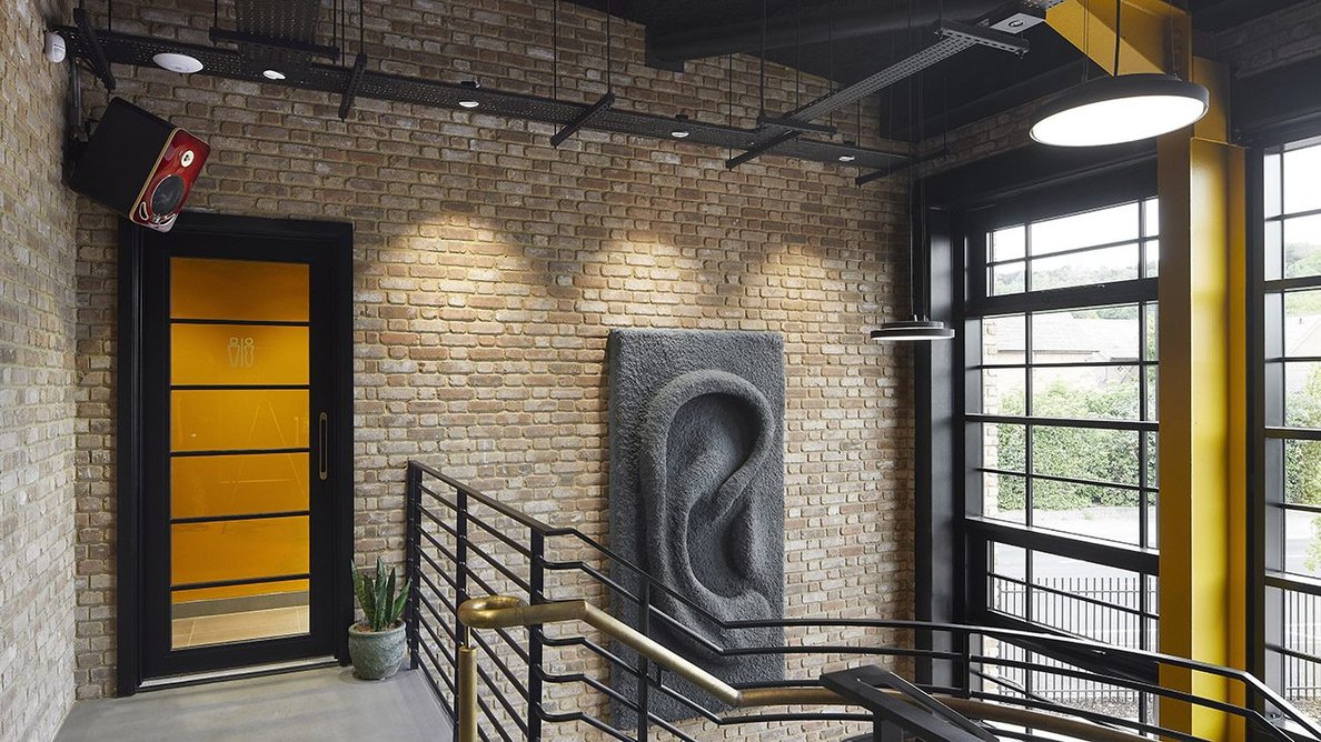 SonaSpray K-13 acoustic ceiling spray in black and ear sculpture made of SonaSpray in grey in the welcome lobby.