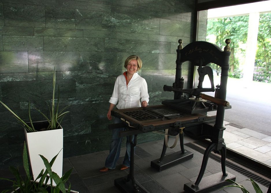 Maria Heyer-Dombrink alongside an early 19th century press in the firm’s 1950s lobby.