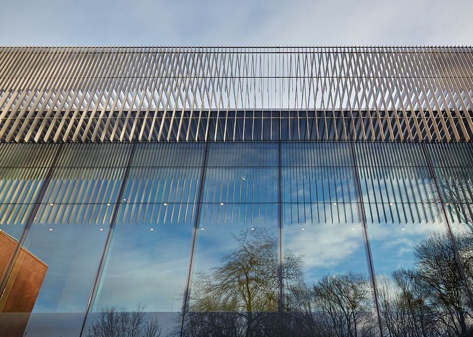 The lighweight brises soleil reflected alongside the park trees.