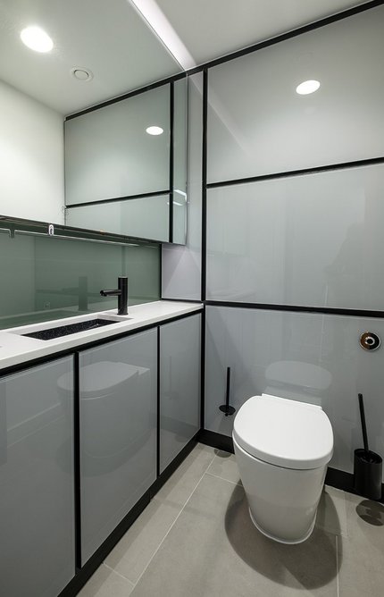 Washroom Washroom superloo with solid surface vanity units and toughened glass duct panels.