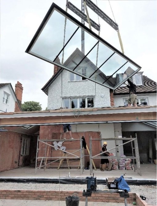 The five-unit north-facing rooflight being craned into position.