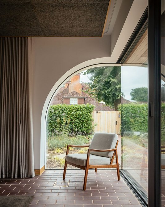 The half arch window in the living room greets visitors arriving on foot and is a nod to the full arched entrance of the previous house.