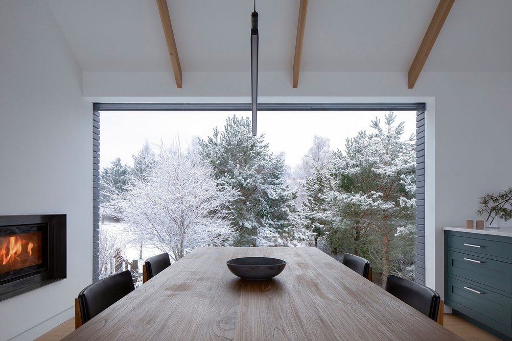 The dining space sits between the kitchen and through fireplace to the sitting area.